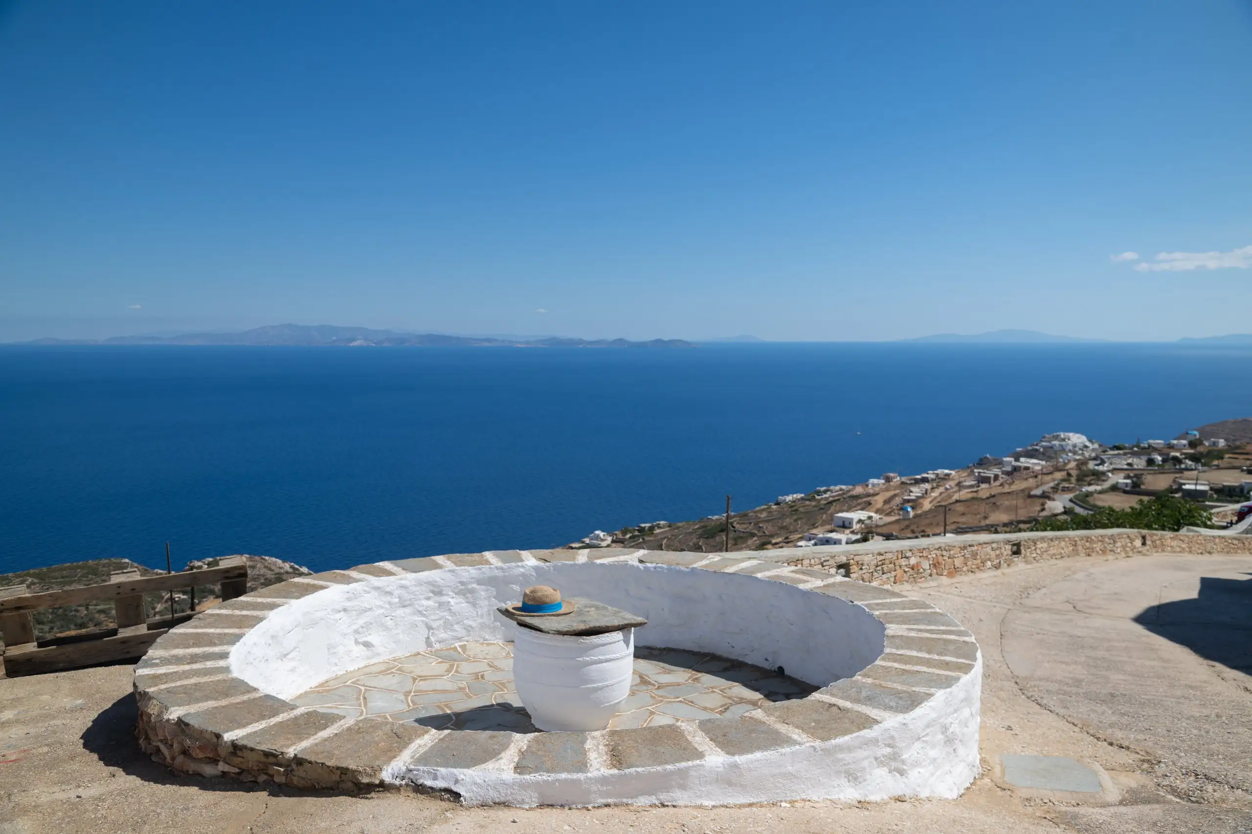 Vue panoramique sur la mer Égée depuis une cour en pierre blanchie à la chaux de Windmill Villas