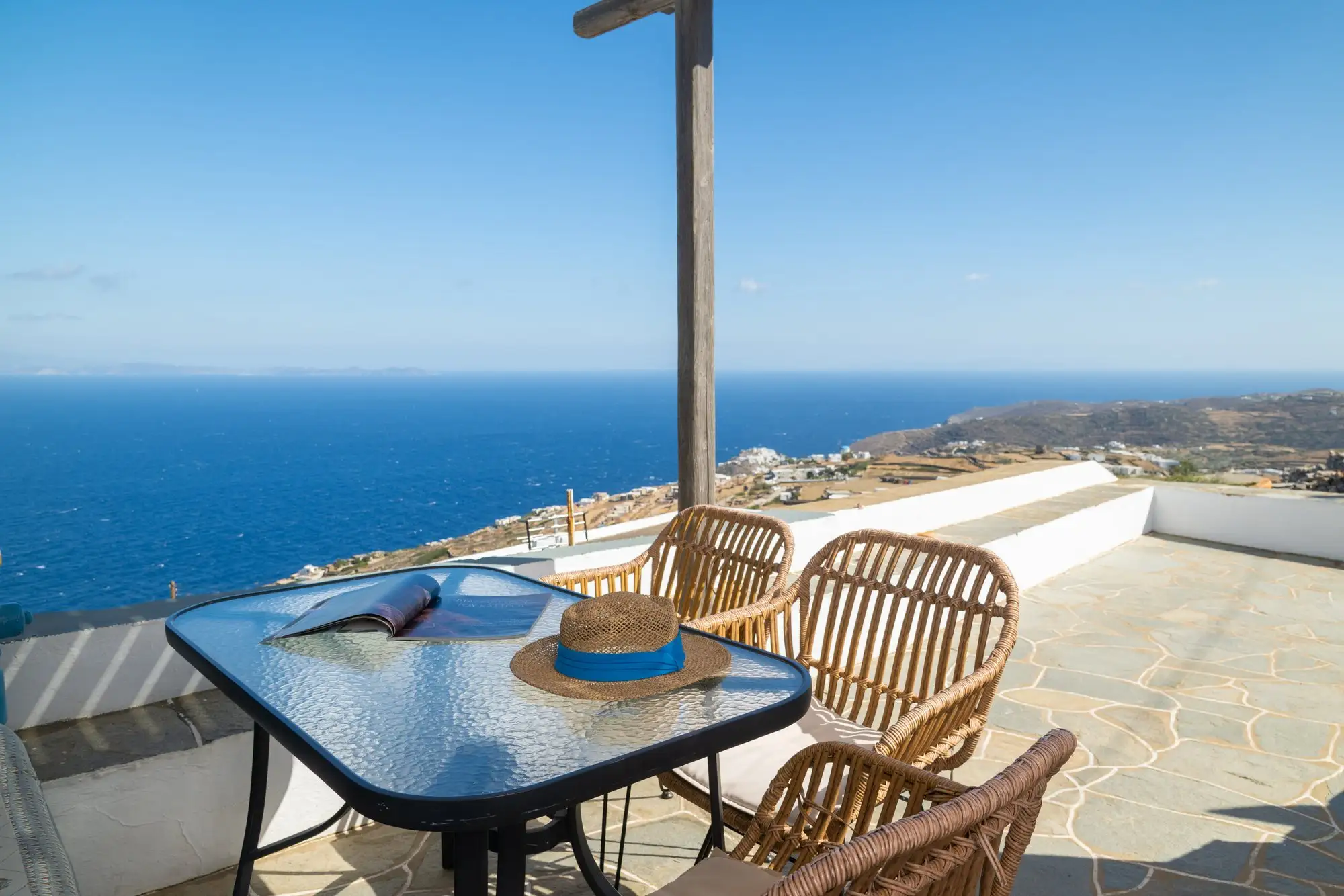 Appartement Eos : table de la terrasse face à la mer et aux îles