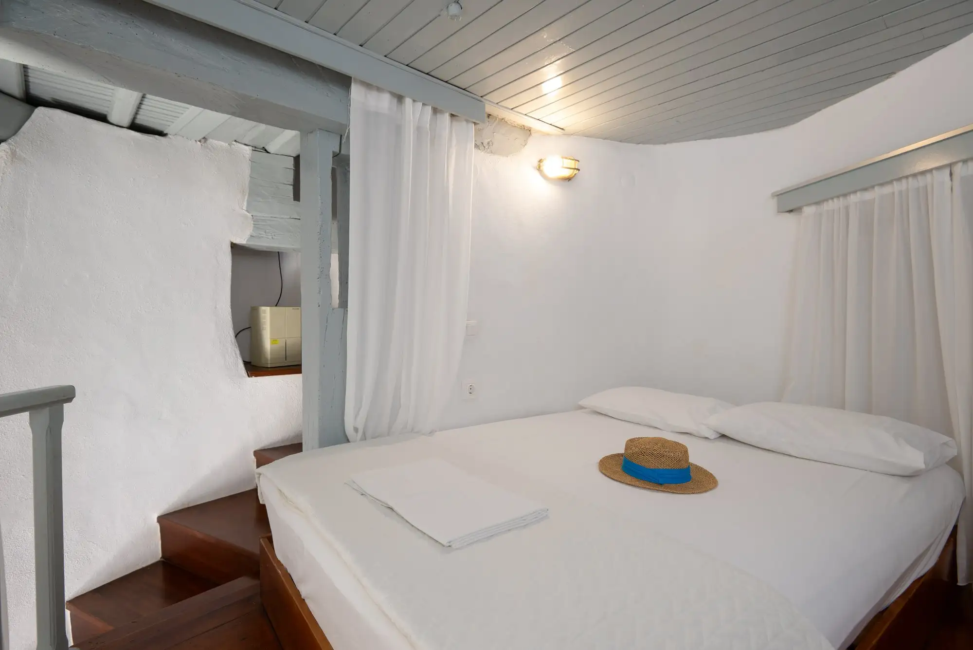 Un lit double entre les murs arrondis du moulin