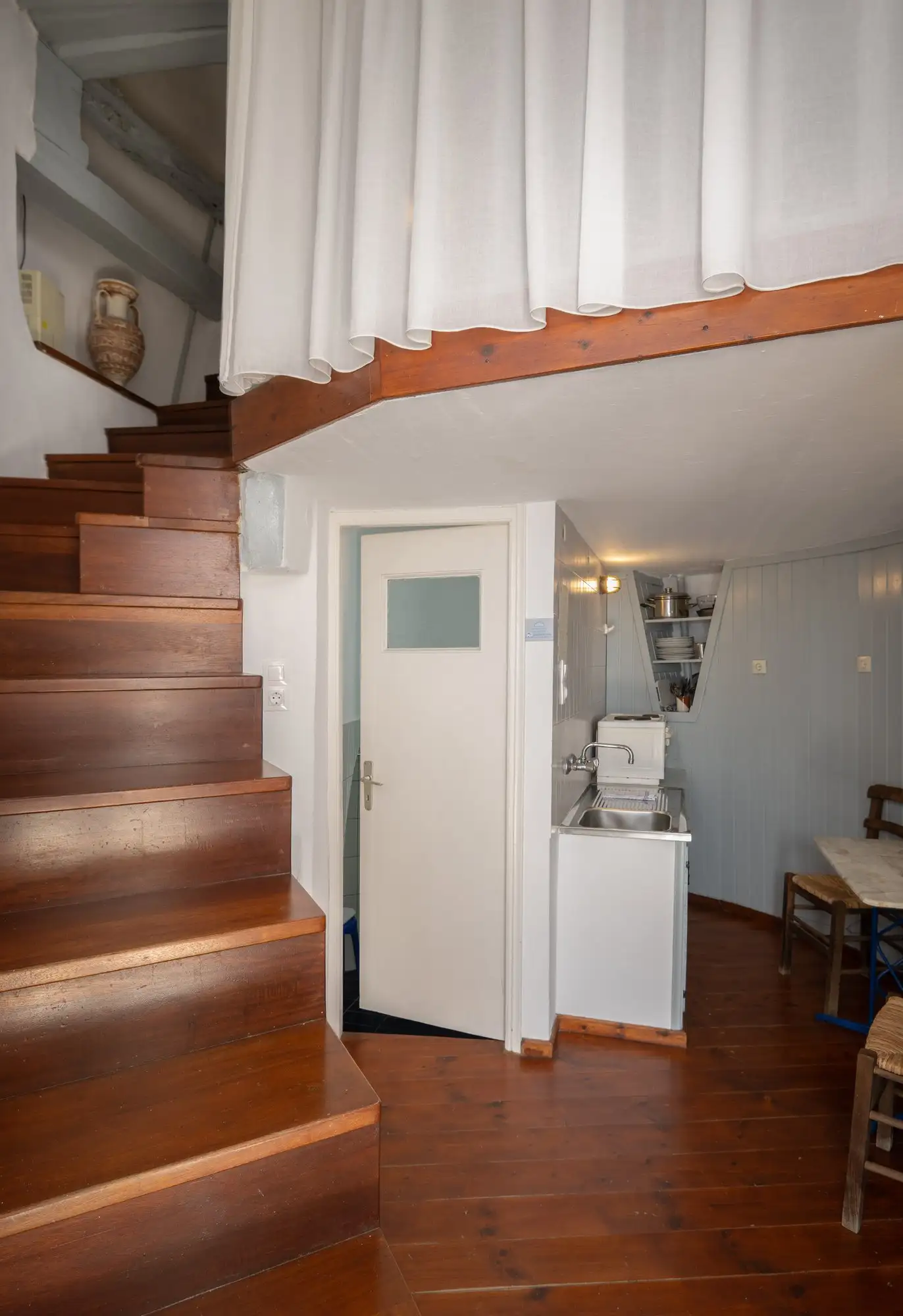 Le rez-de-chaussée du moulin, avec l’escalier en bois et la cuisine