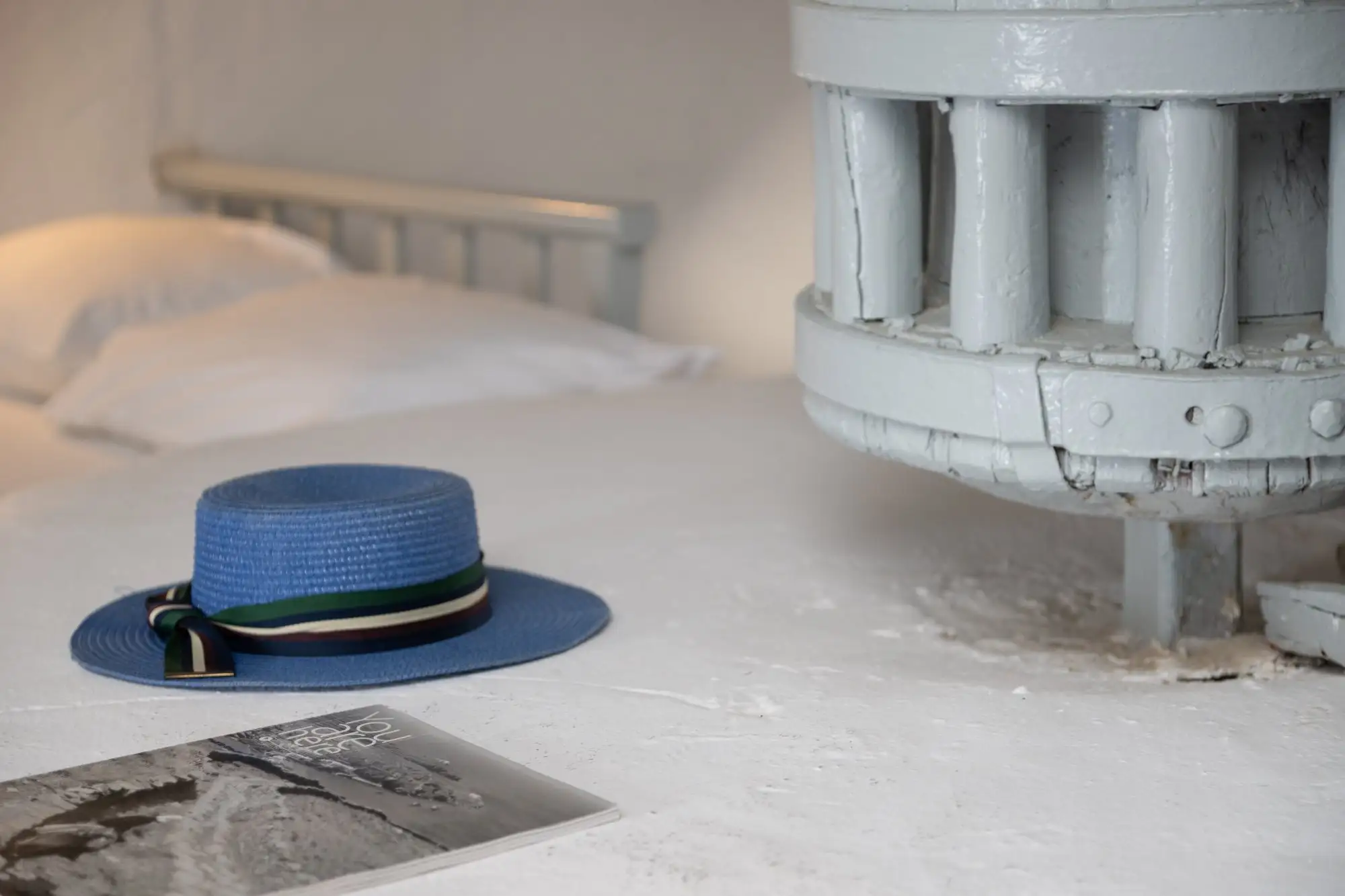 Un chapeau de paille bleu sur la meule, à côté de l’engrenage en bois