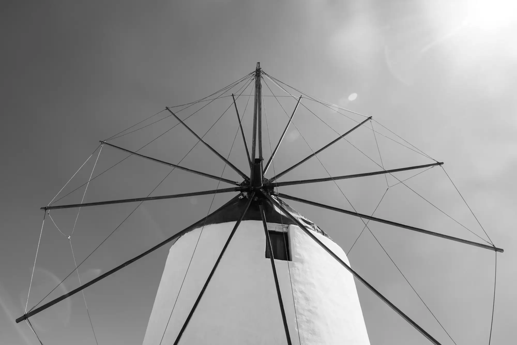 Les rayons des ailes du moulin, photographiés en noir et blanc d’en bas