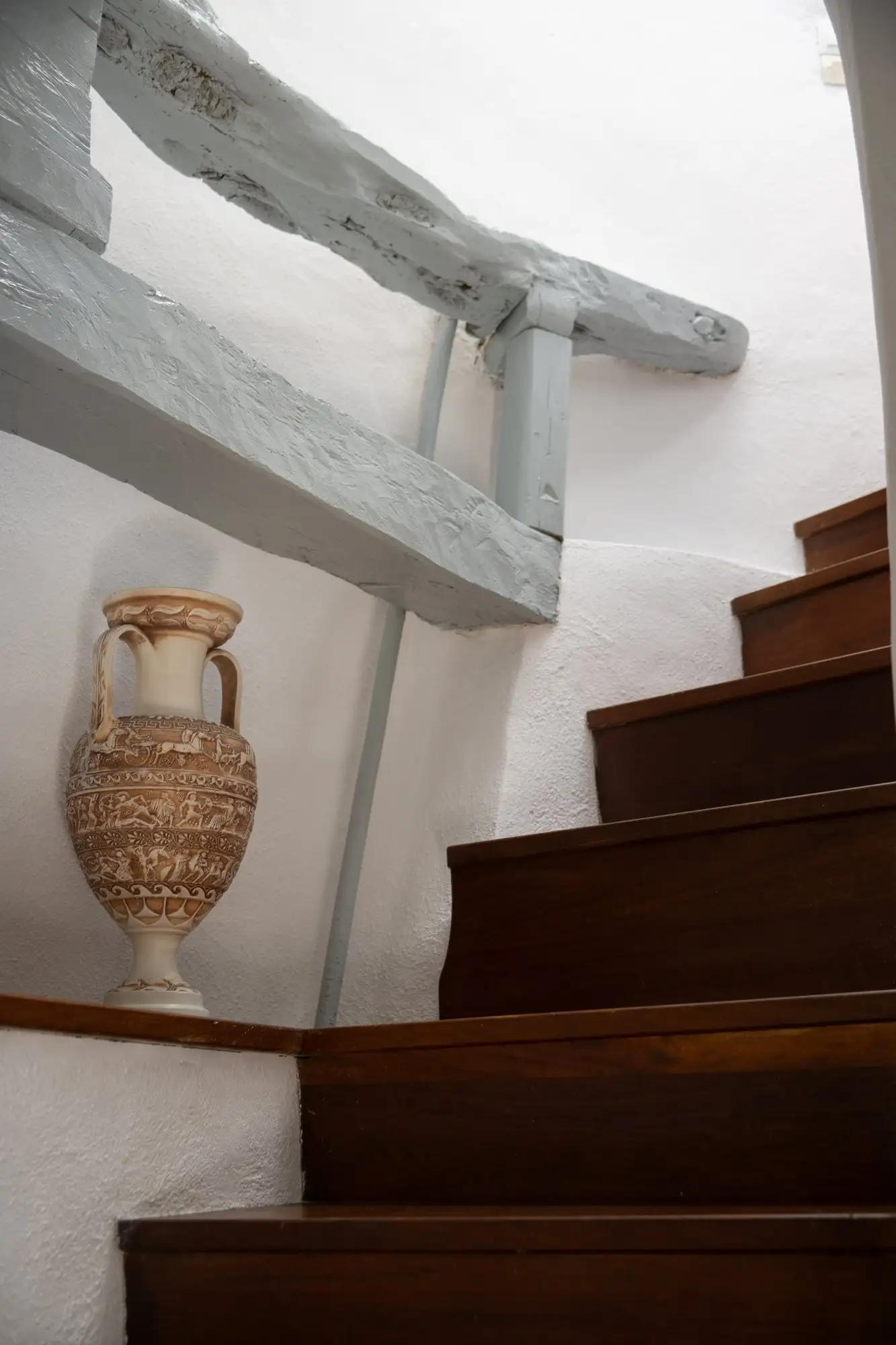 Une amphore au tournant de l’escalier en bois du moulin
